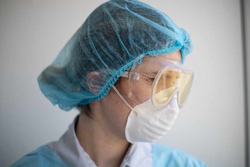 Nurse wearing personal protective equipment (PPE); goggles, mask, hair net